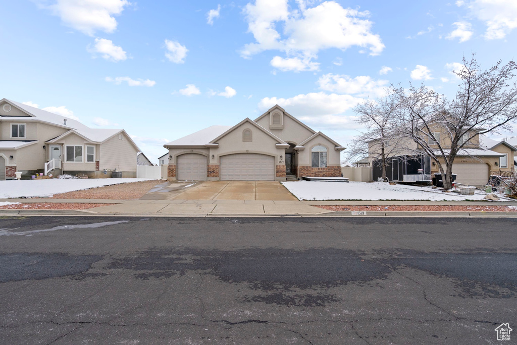 View of front of house with a garage, fence, concrete driveway, and stucco siding