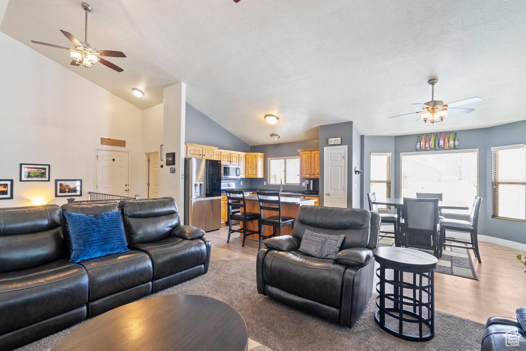 Living area featuring a wealth of natural light, light wood-type flooring, and ceiling fan