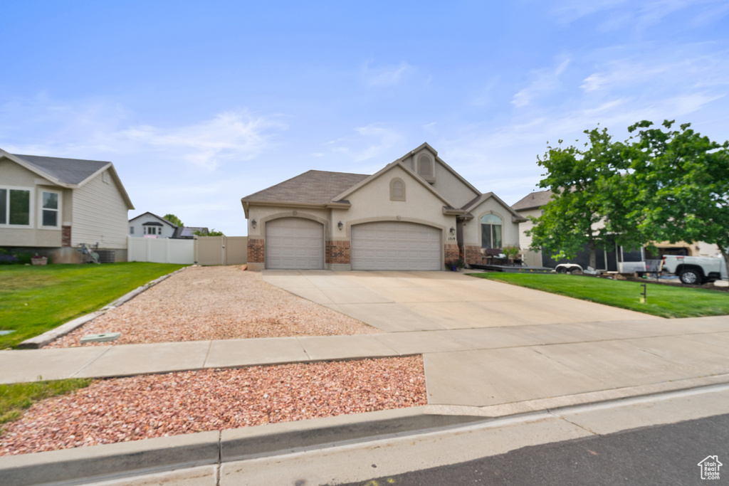 View of front of property featuring driveway, a garage, and stucco siding