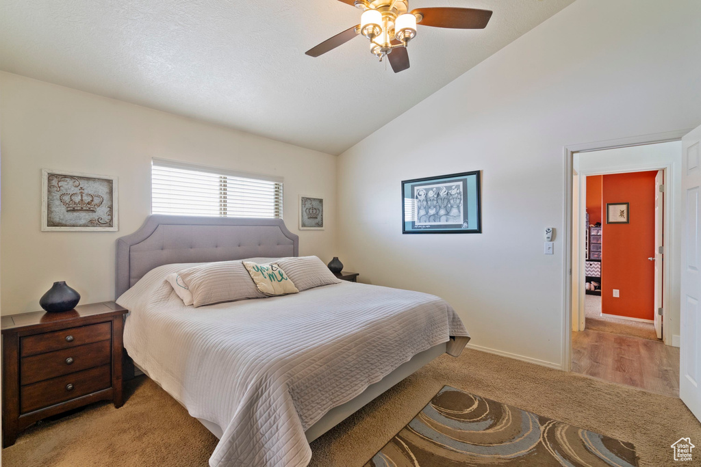 Bedroom featuring baseboards, light colored carpet, a ceiling fan, and vaulted ceiling
