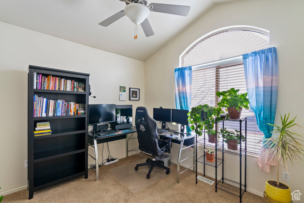 Office featuring vaulted ceiling, carpet flooring, baseboards, and ceiling fan