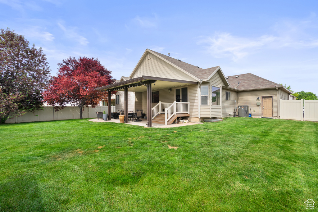 Rear view of house with a patio, a pergola, and roof with shingles