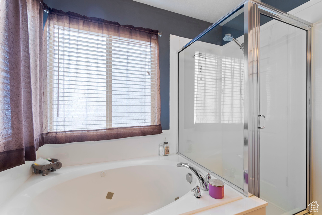 Full bathroom featuring a garden tub and a stall shower