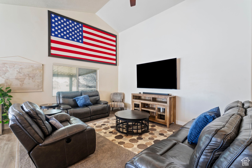 Living area featuring high vaulted ceiling, wood finished floors, and a ceiling fan