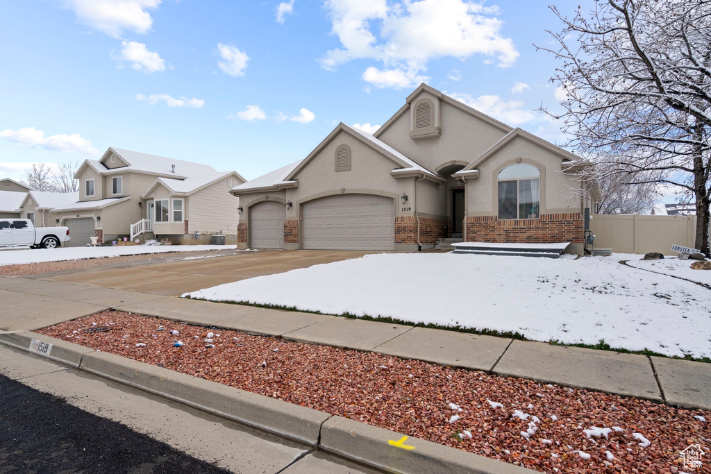 View of front of house featuring fence, a garage, driveway, and stucco siding