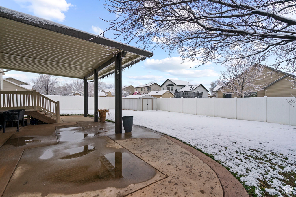 Exterior space featuring a fenced backyard, a residential view, a storage unit, and an outdoor structure