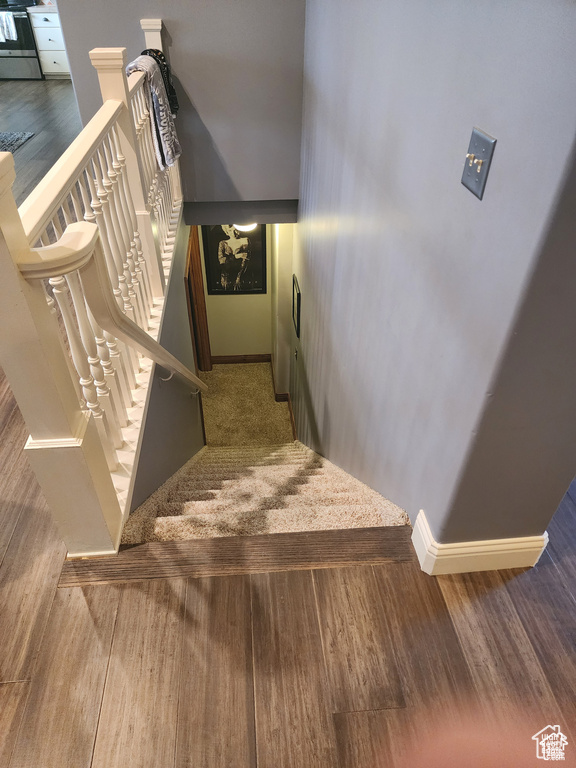 Stairs with baseboards and wood finished floors