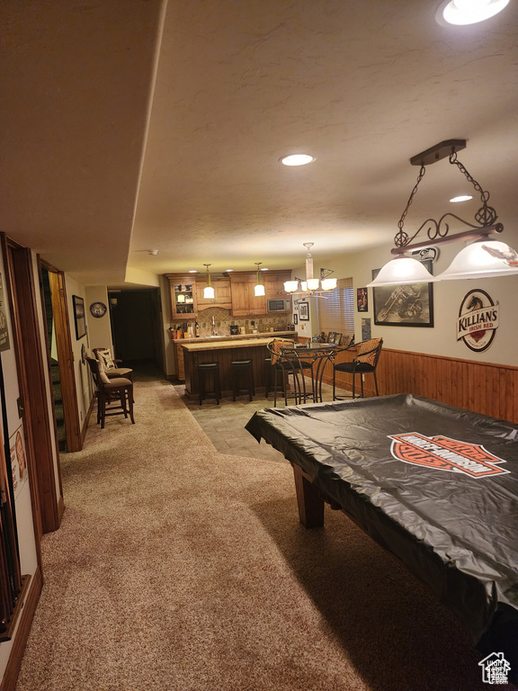 Recreation room featuring wooden walls, a wainscoted wall, recessed lighting, bar, and light carpet