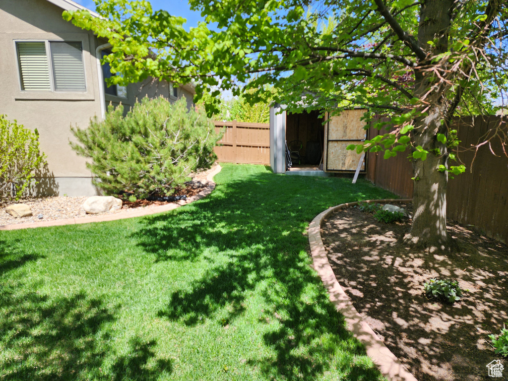 View of yard with a shed, an outdoor structure, and a fenced backyard