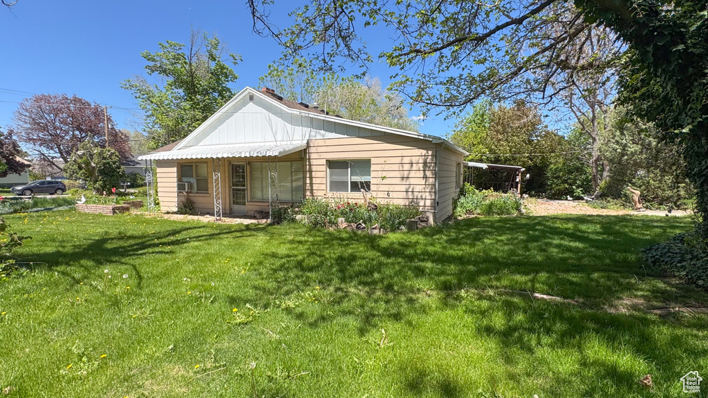Rear view of house featuring a yard
