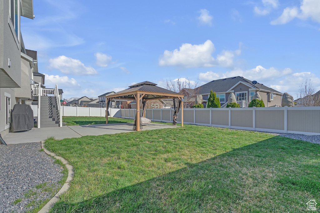 View of yard with stairway, a gazebo, a fenced backyard, a residential view, and a patio
