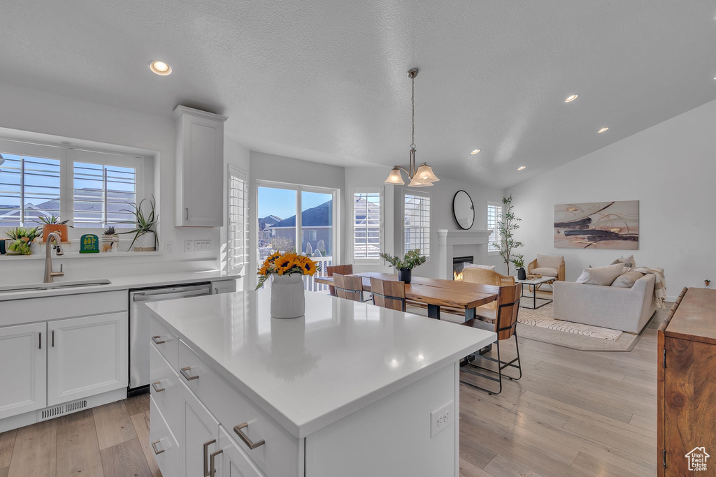Kitchen featuring light countertops, stainless steel dishwasher, a sink, light wood-style floors, and visible vents