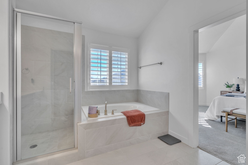 Ensuite bathroom featuring tile patterned floors, vaulted ceiling, a shower stall, ensuite bathroom, and a bath