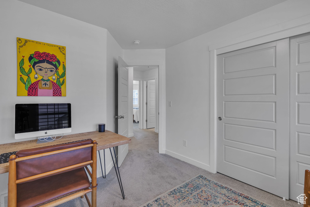 Carpeted office space with baseboards
