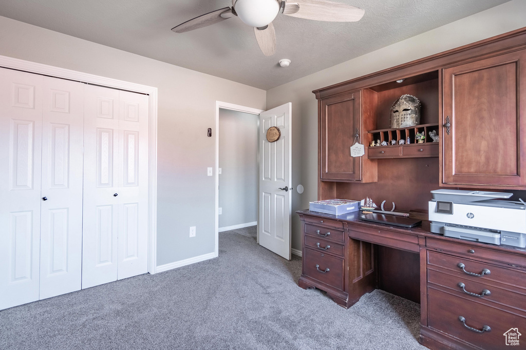 Office space with light colored carpet, ceiling fan, and baseboards
