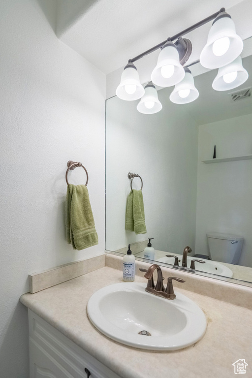 Bathroom with visible vents, toilet, and vanity