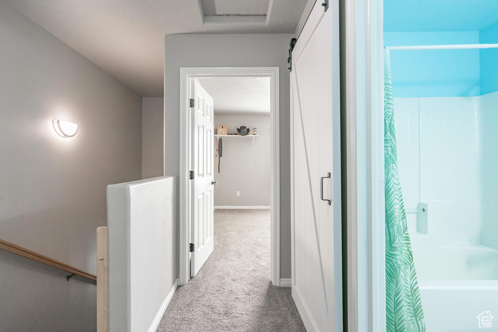 Corridor featuring baseboards, an upstairs landing, and carpet floors