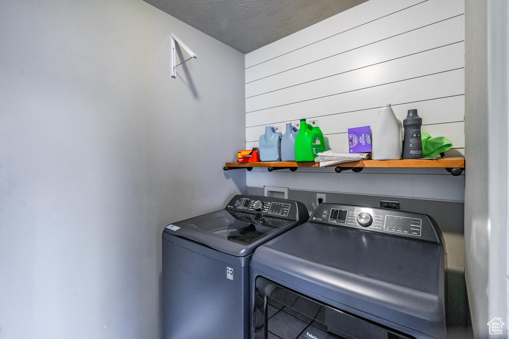 Washroom featuring washer and dryer, laundry area, and a textured ceiling