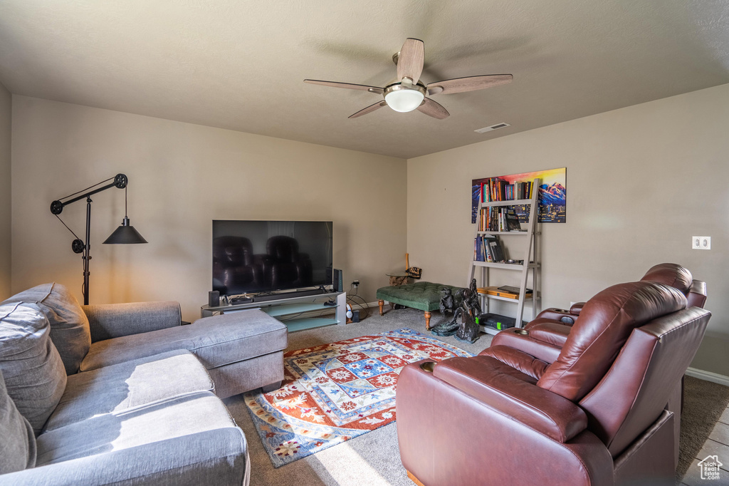 Living area featuring carpet flooring, a ceiling fan, baseboards, and visible vents