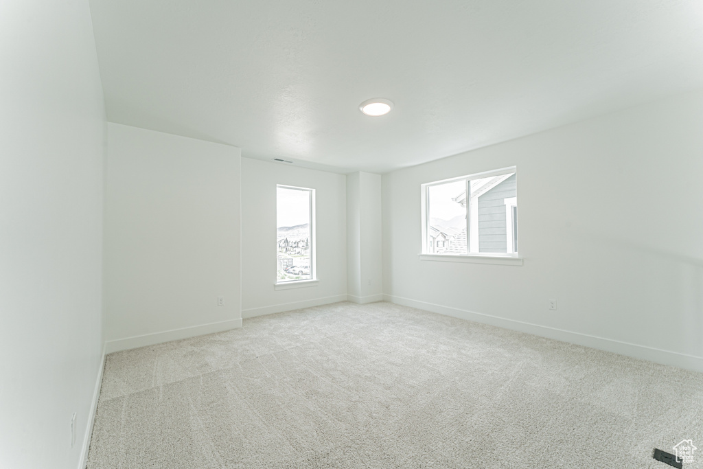 Carpeted spare room with baseboards