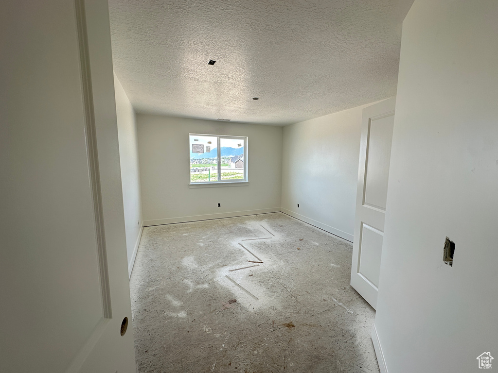 Unfurnished room with a textured ceiling