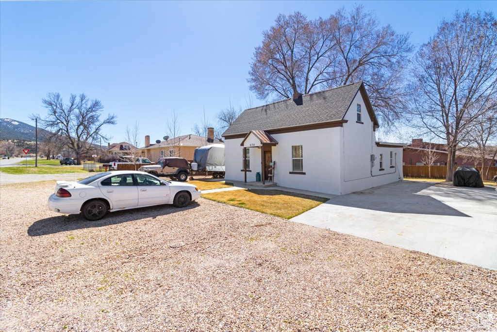 View of side of home with a shingled roof