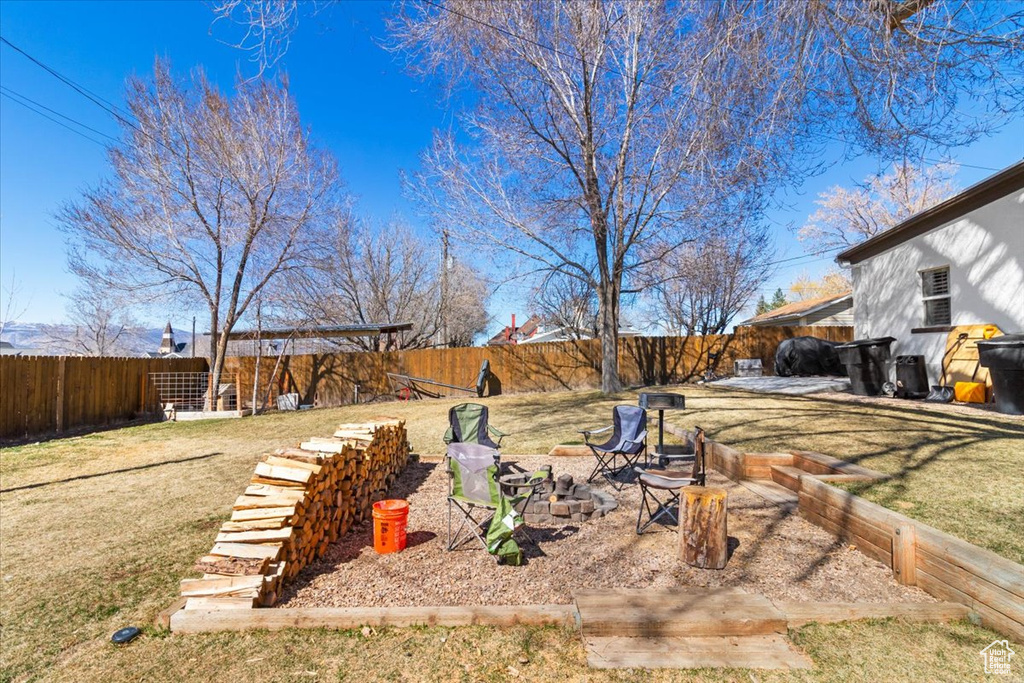 View of yard featuring a fenced backyard and a fire pit