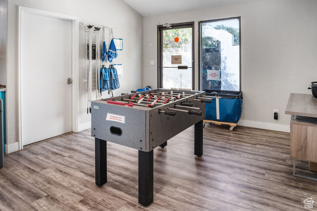 Recreation room with baseboards, wood finished floors, and lofted ceiling