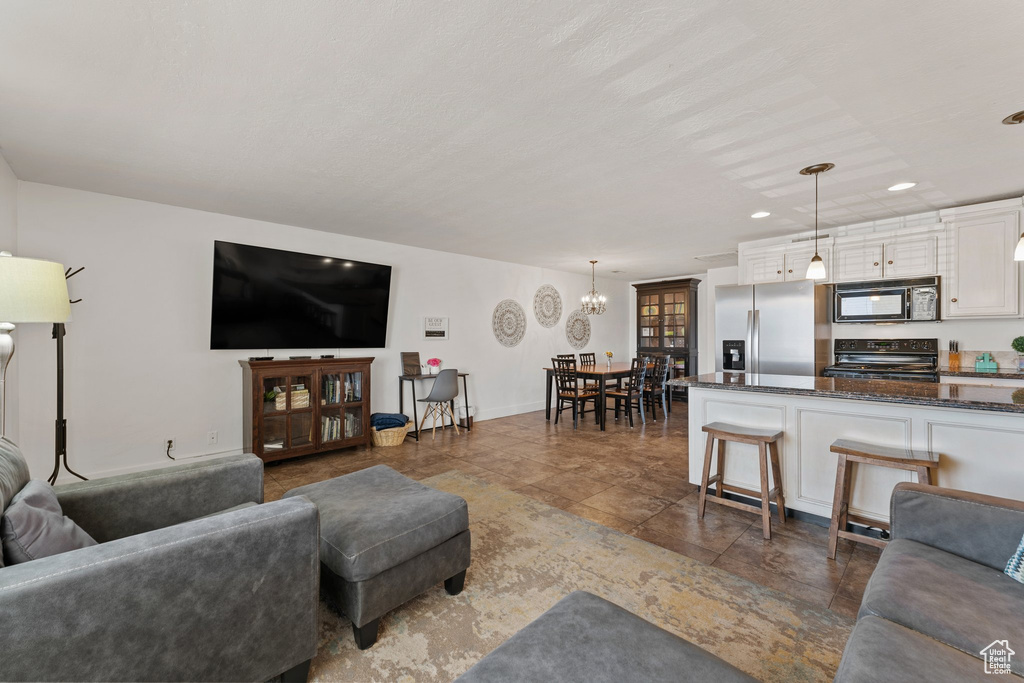 Living room with recessed lighting, baseboards, a chandelier, and stone finish flooring