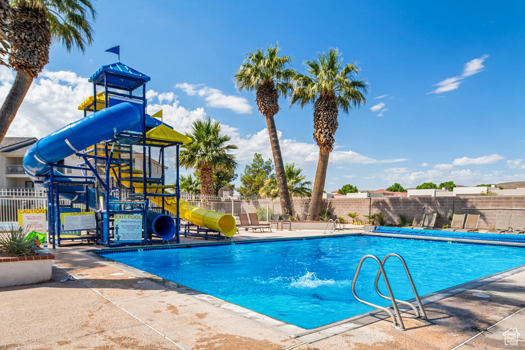 Pool with fence, a water slide, and playground community
