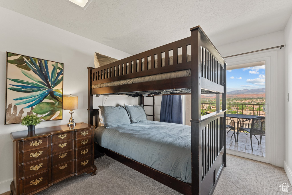 Carpeted bedroom featuring baseboards, access to outside, and a mountain view