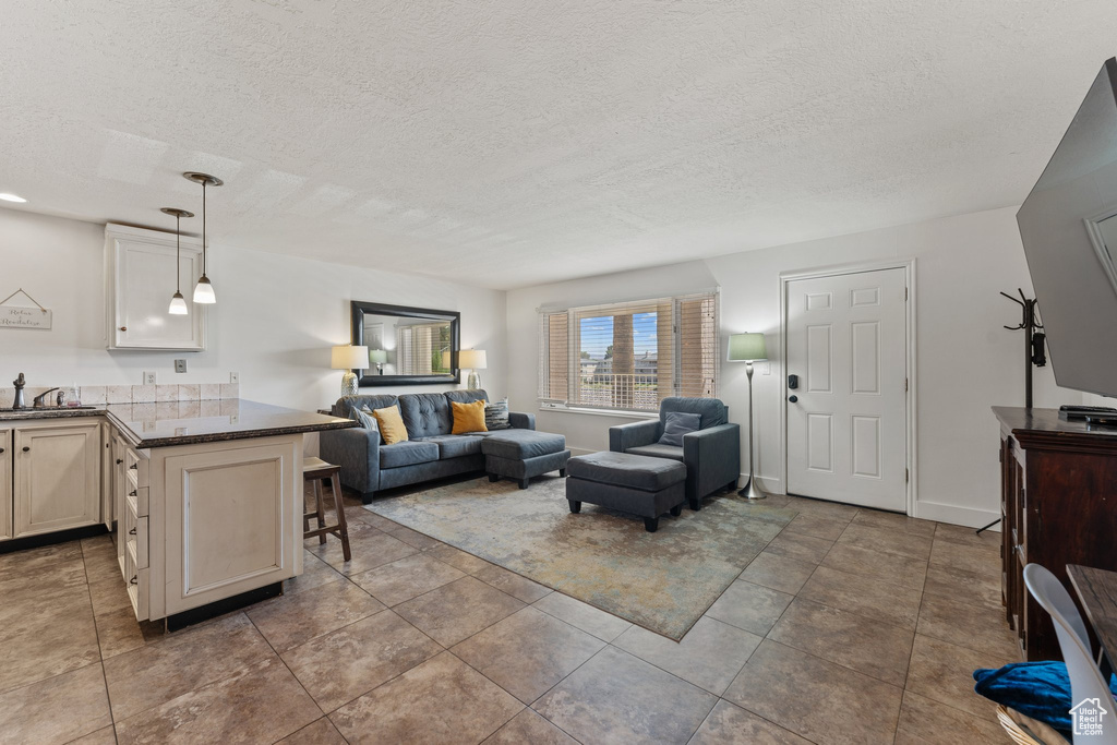 Living room with tile patterned floors and a textured ceiling