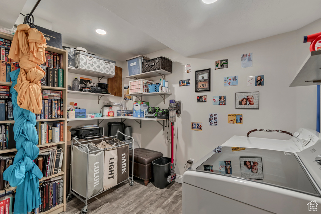 Laundry room with separate washer and dryer, wood finished floors, laundry area, baseboards, and recessed lighting