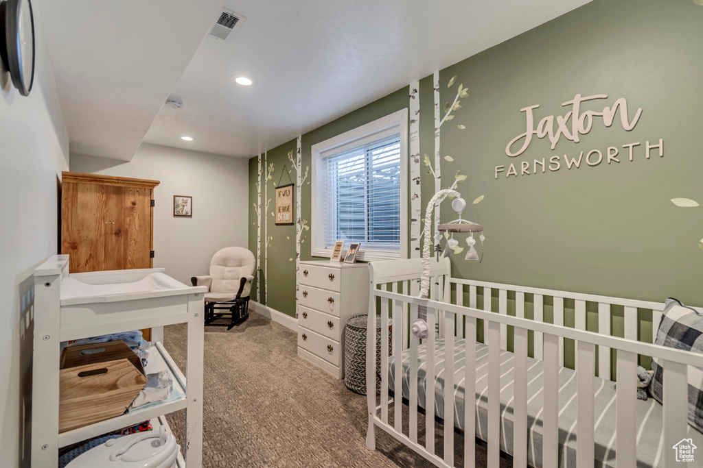 Bedroom featuring carpet floors, visible vents, recessed lighting, and a crib