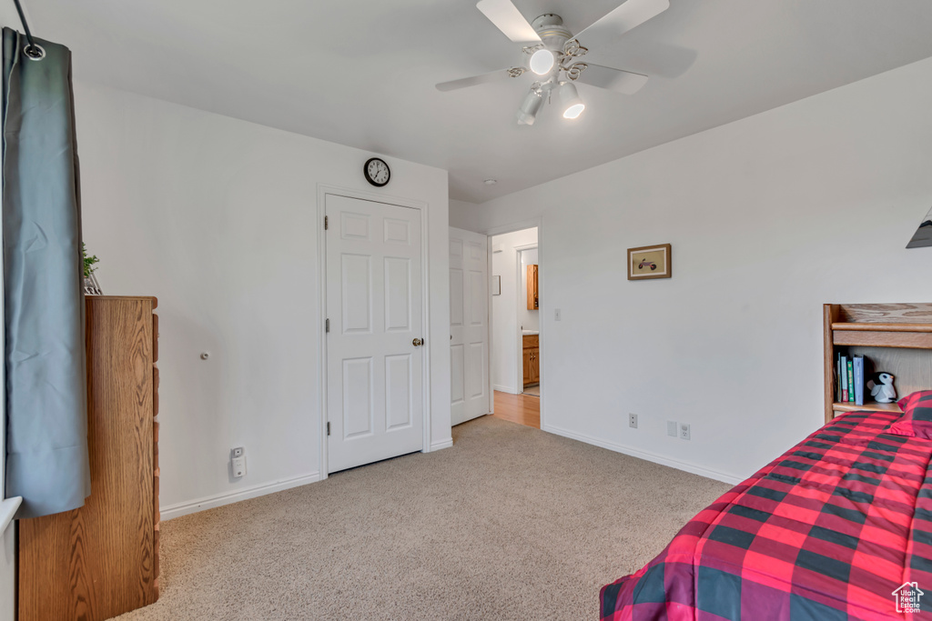 Carpeted bedroom featuring baseboards and ceiling fan