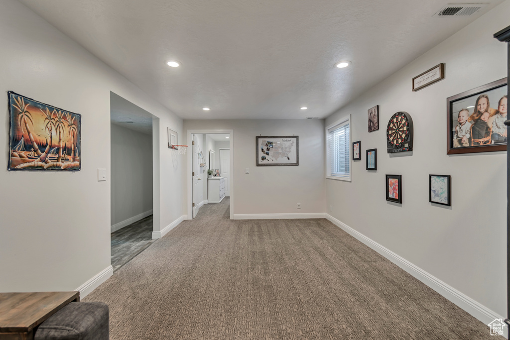 Interior space featuring baseboards, visible vents, recessed lighting, and carpet