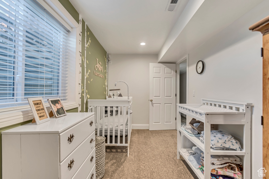 Bedroom featuring a crib, baseboards, light colored carpet, visible vents, and recessed lighting