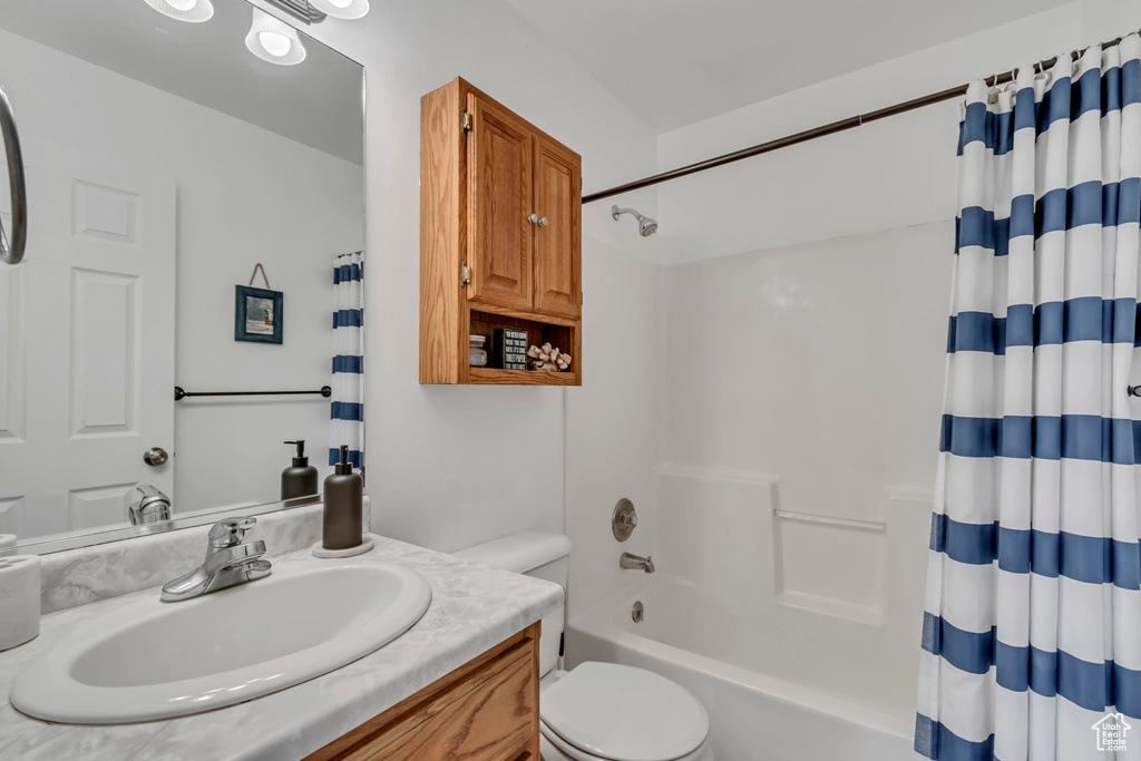 Bathroom featuring shower / tub combo, toilet, and vanity