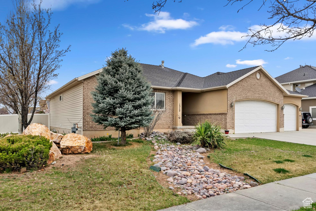 Single story home with driveway, a front yard, fence, an attached garage, and brick siding