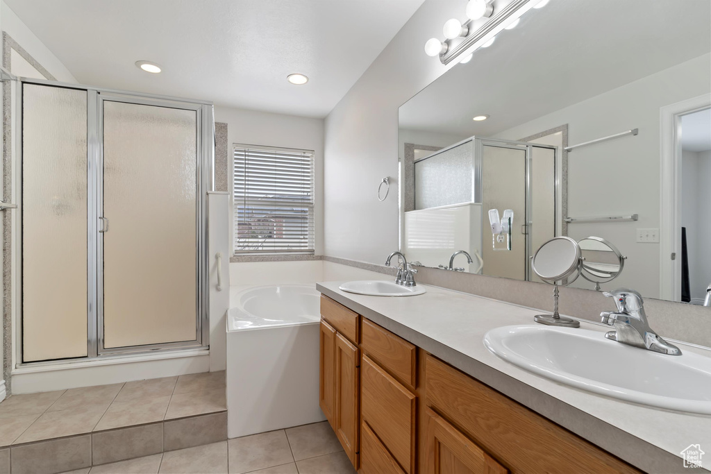 Full bathroom featuring a garden tub, a sink, tile patterned floors, and a shower stall