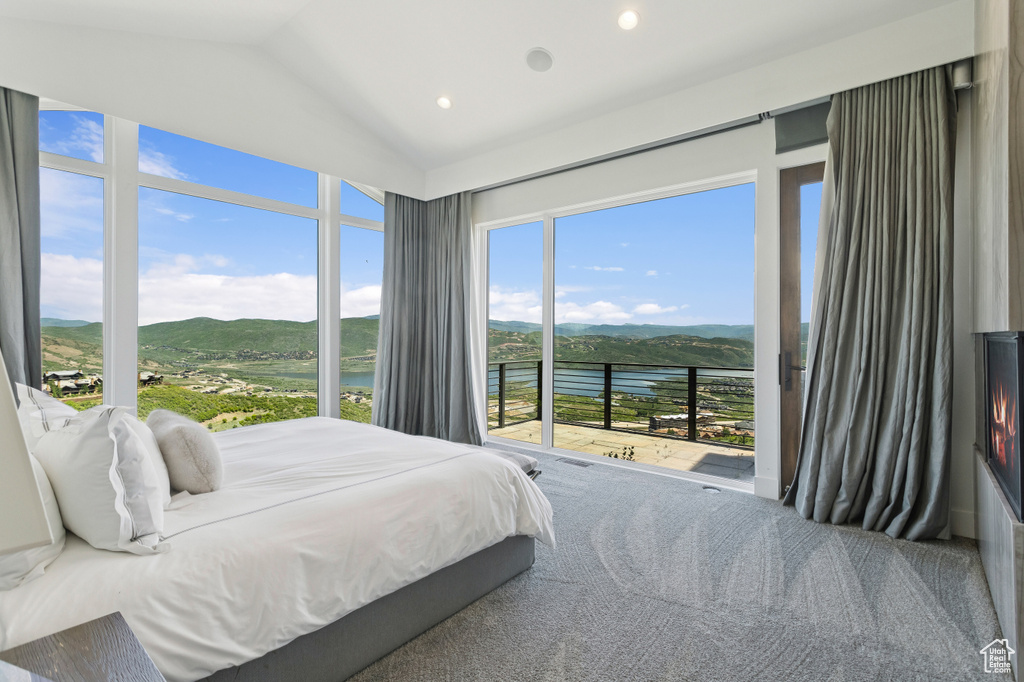 Carpeted bedroom featuring access to outside, vaulted ceiling, a water and mountain view, and recessed lighting
