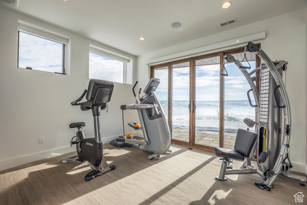 Workout area with recessed lighting and a water view