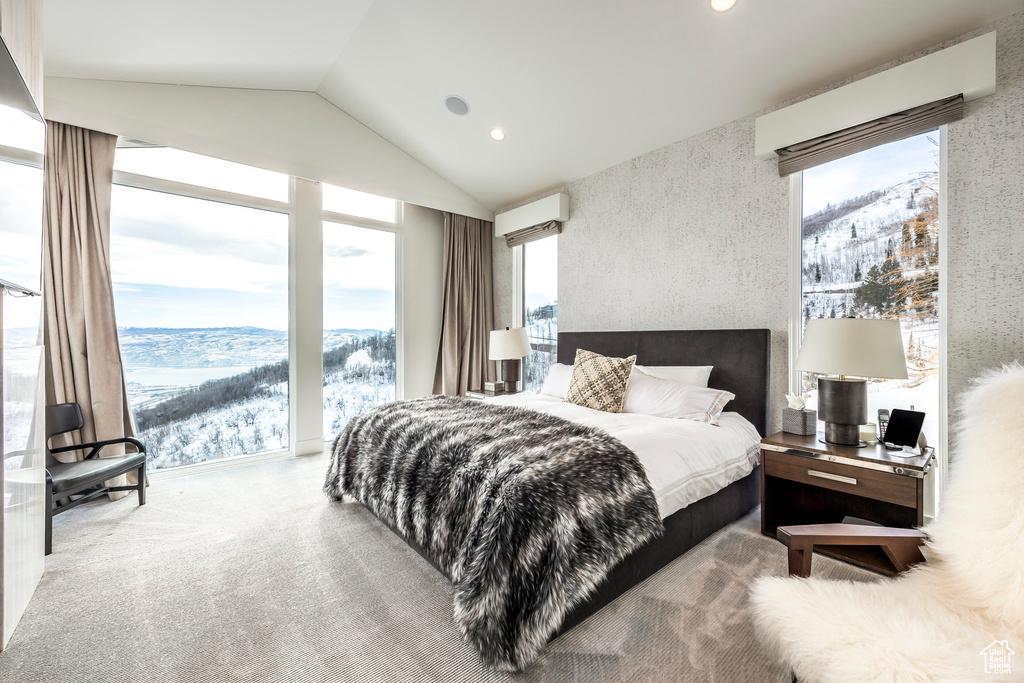 Bedroom featuring vaulted ceiling, multiple windows, an AC wall unit, recessed lighting, and a mountain view