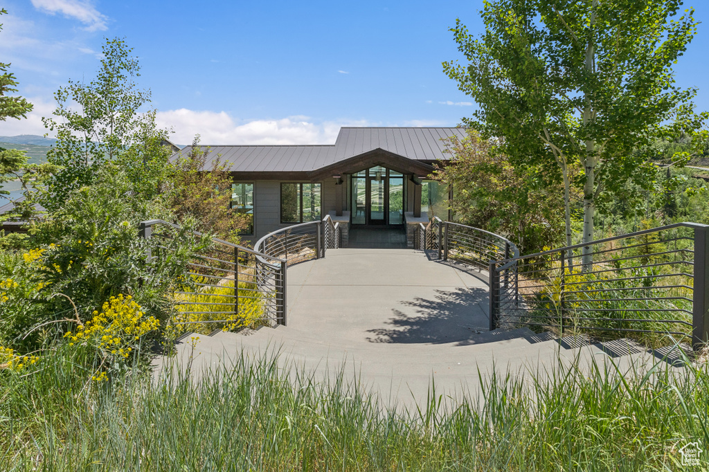 View of front of house with driveway, french doors, a metal roof, and a standing seam roof