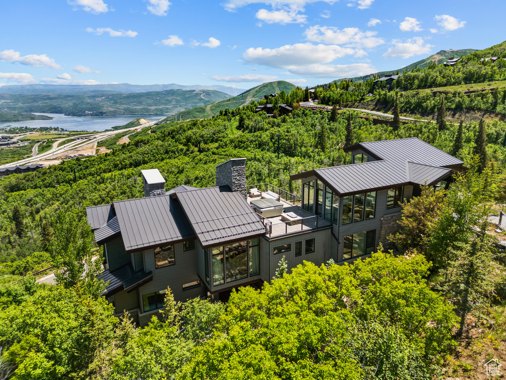 Drone / aerial view of a water and mountain view and a heavily wooded area