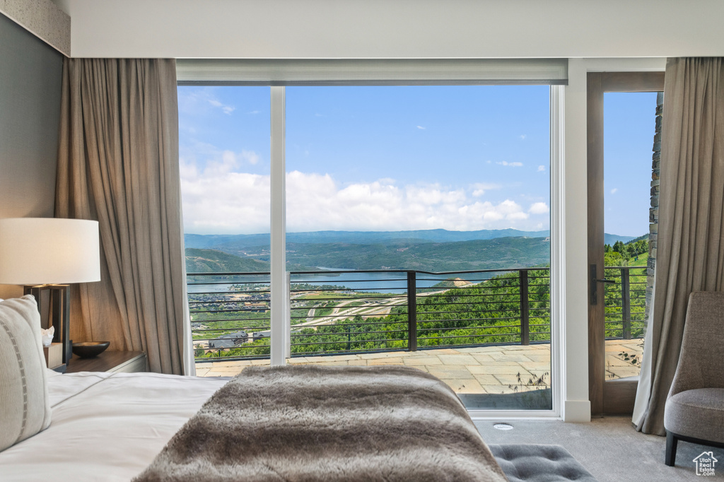 Carpeted bedroom featuring a water and mountain view and multiple windows