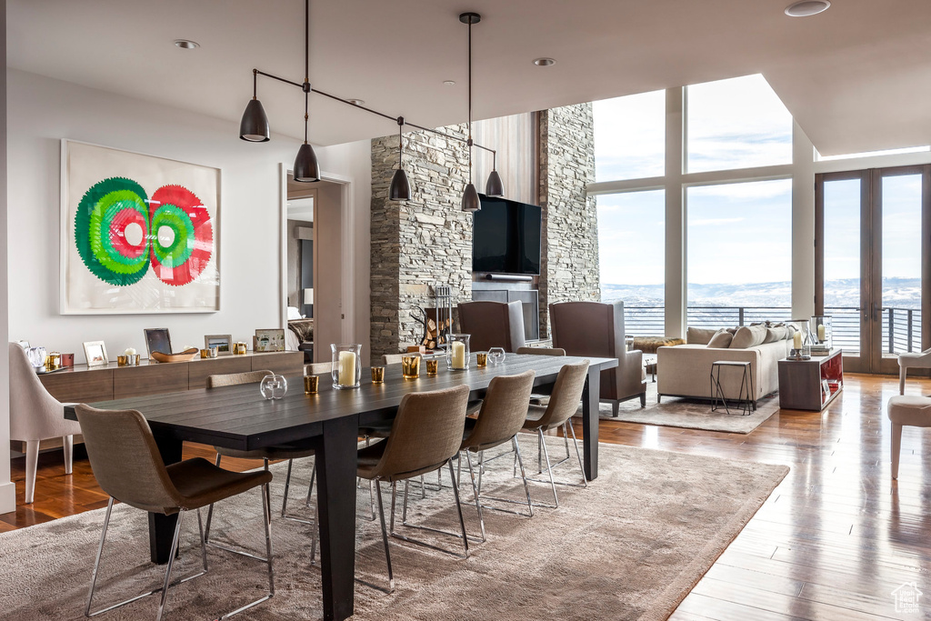 Dining room featuring plenty of natural light, wood finished floors, and a wall of windows