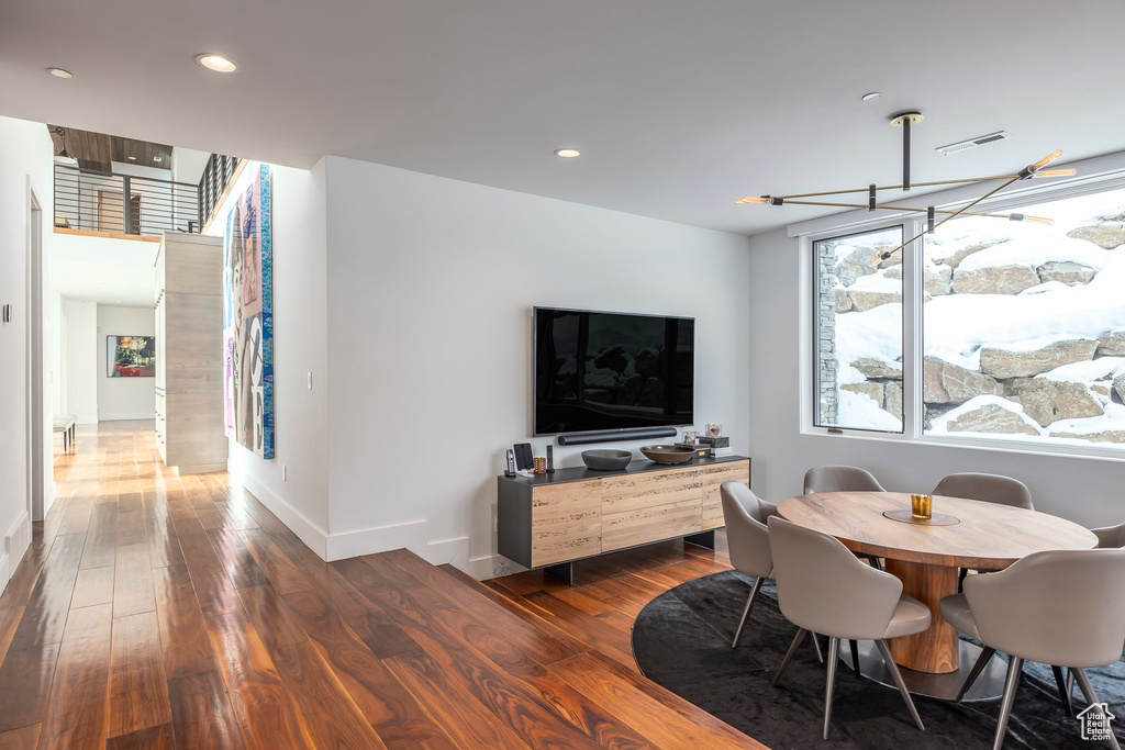 Dining area with dark wood-type flooring and recessed lighting