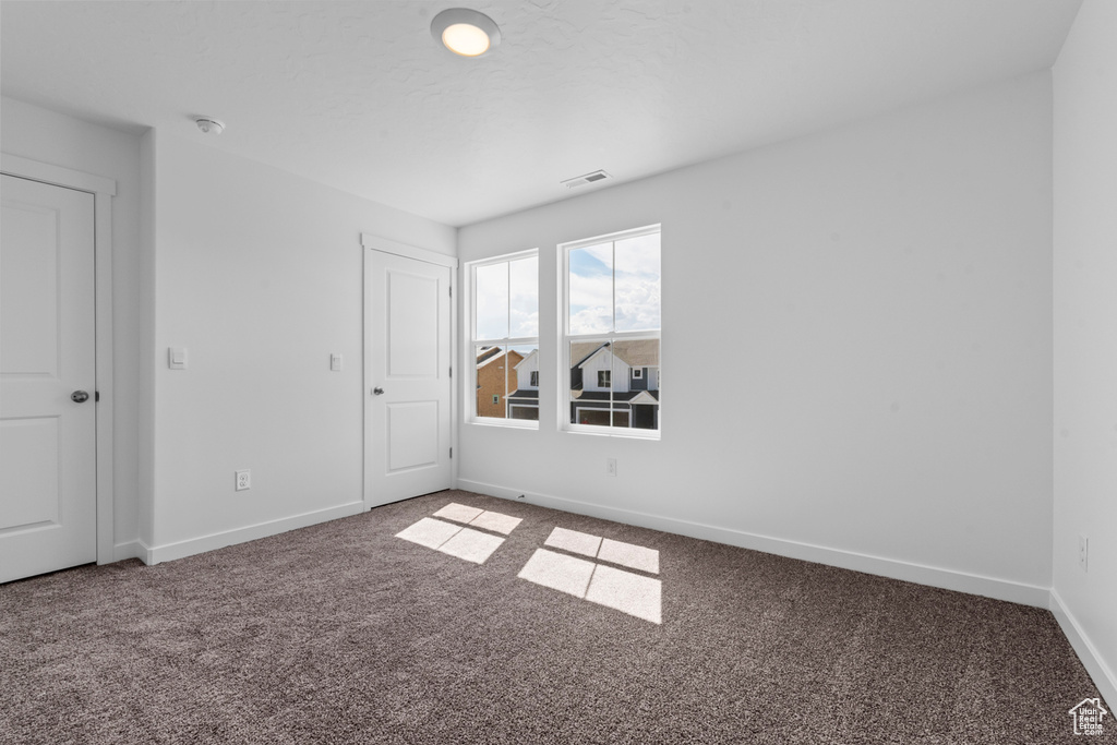 Spare room with baseboards, carpet flooring, and visible vents