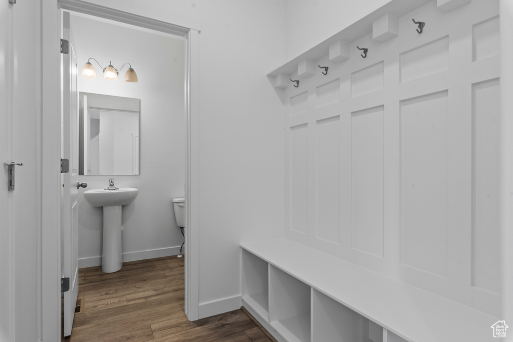 Mudroom featuring baseboards, a sink, and dark wood finished floors